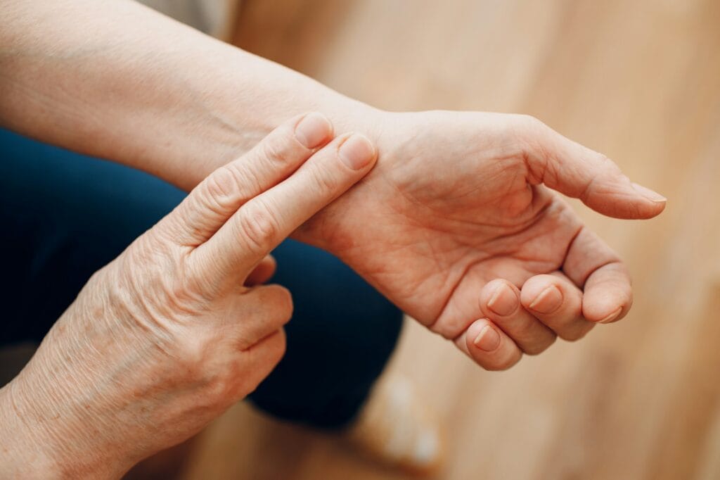 Female old hand measuring her own arm pulse. Elderly woman heart health